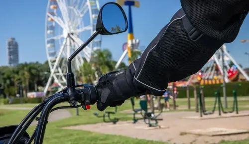 Detalhe do guidão com mão acionando partida elétrica Pop 110i ES