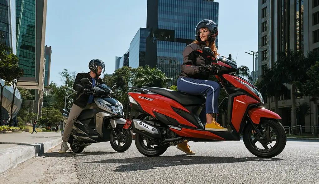 Elite 125 vermelha em movimento, destaque para motor eSP